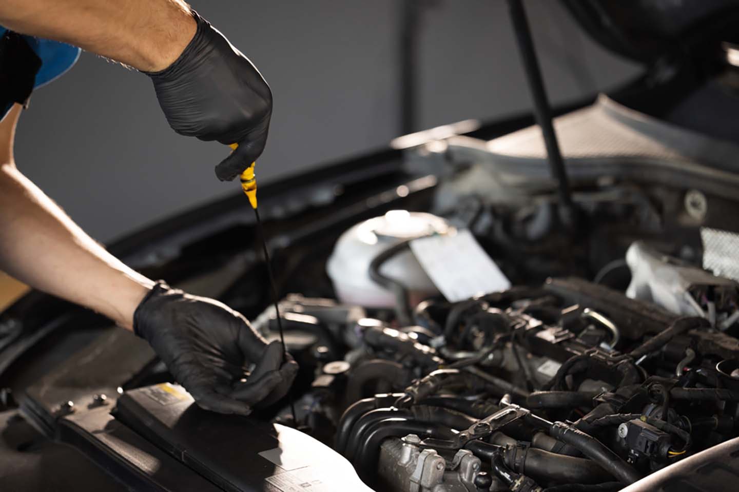 automotive mechanic checks oil level