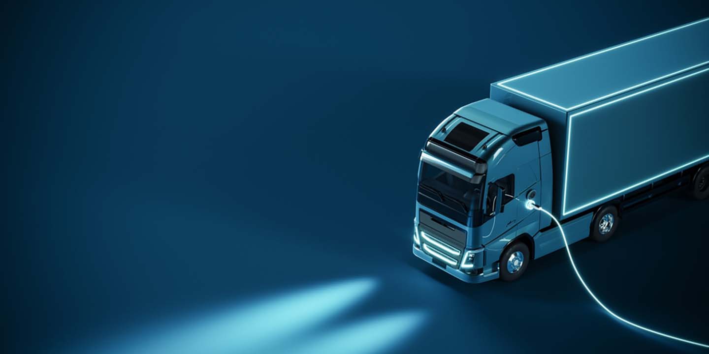 blue electric truck connected to charger