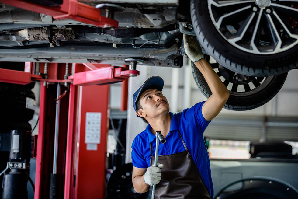 mechanic holding tool under car